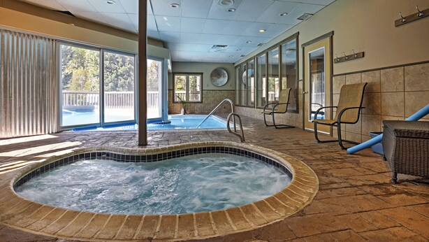 A hot tub area with a pool view, a chair, and a wicker chair. - Creekside Frisco Condo w/ Views & Pool Access! (Frisco)