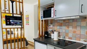 Keittiössä on mikroaaltouuni, kahvinkeitin ja pesuallas. Puiseen väliseinään on asennettu televisio.