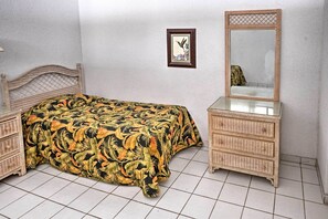 Um quarto com cama, cômoda e um quadro na parede.