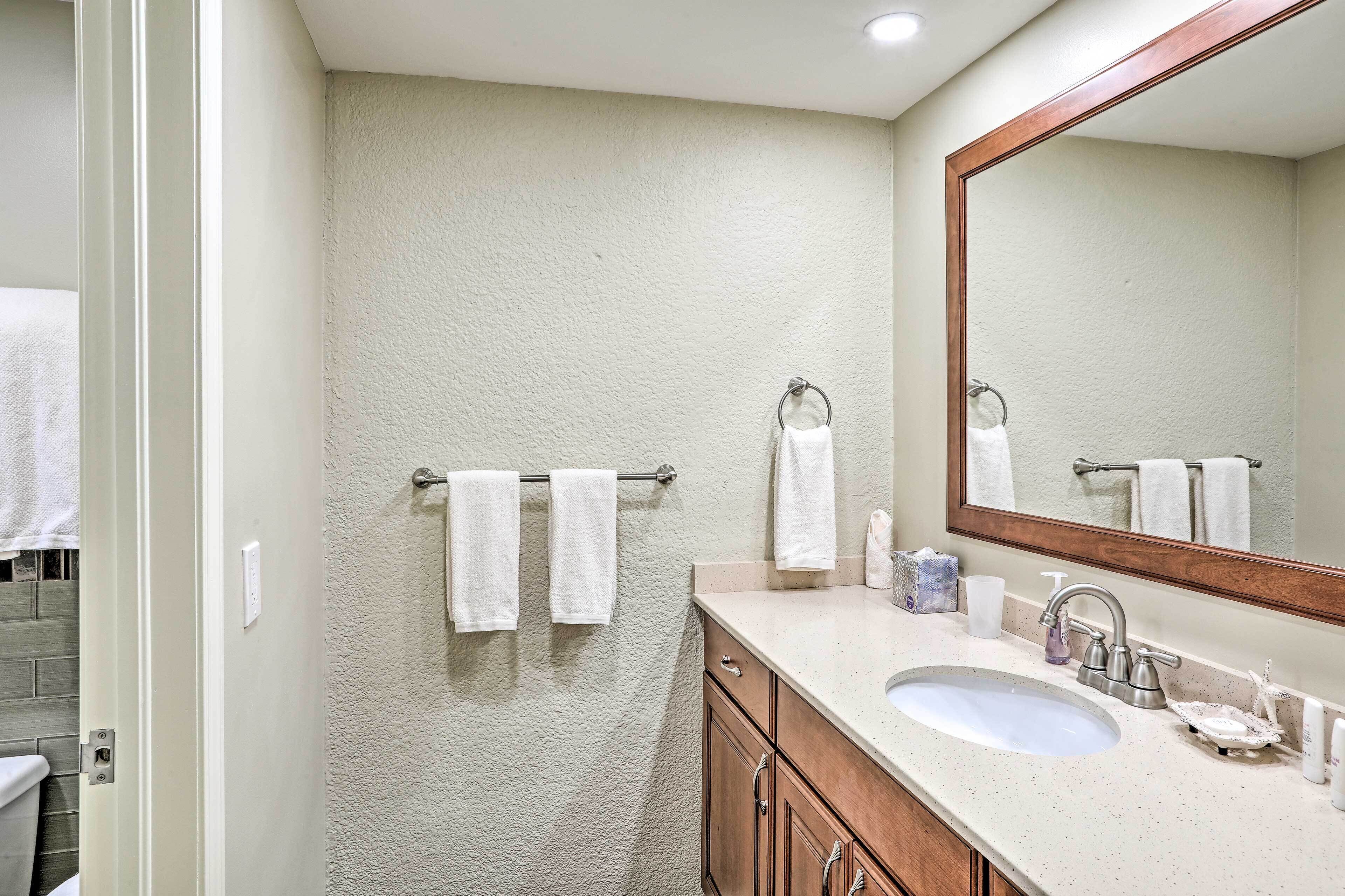 A bathroom with a sink, mirror, and towel rack.