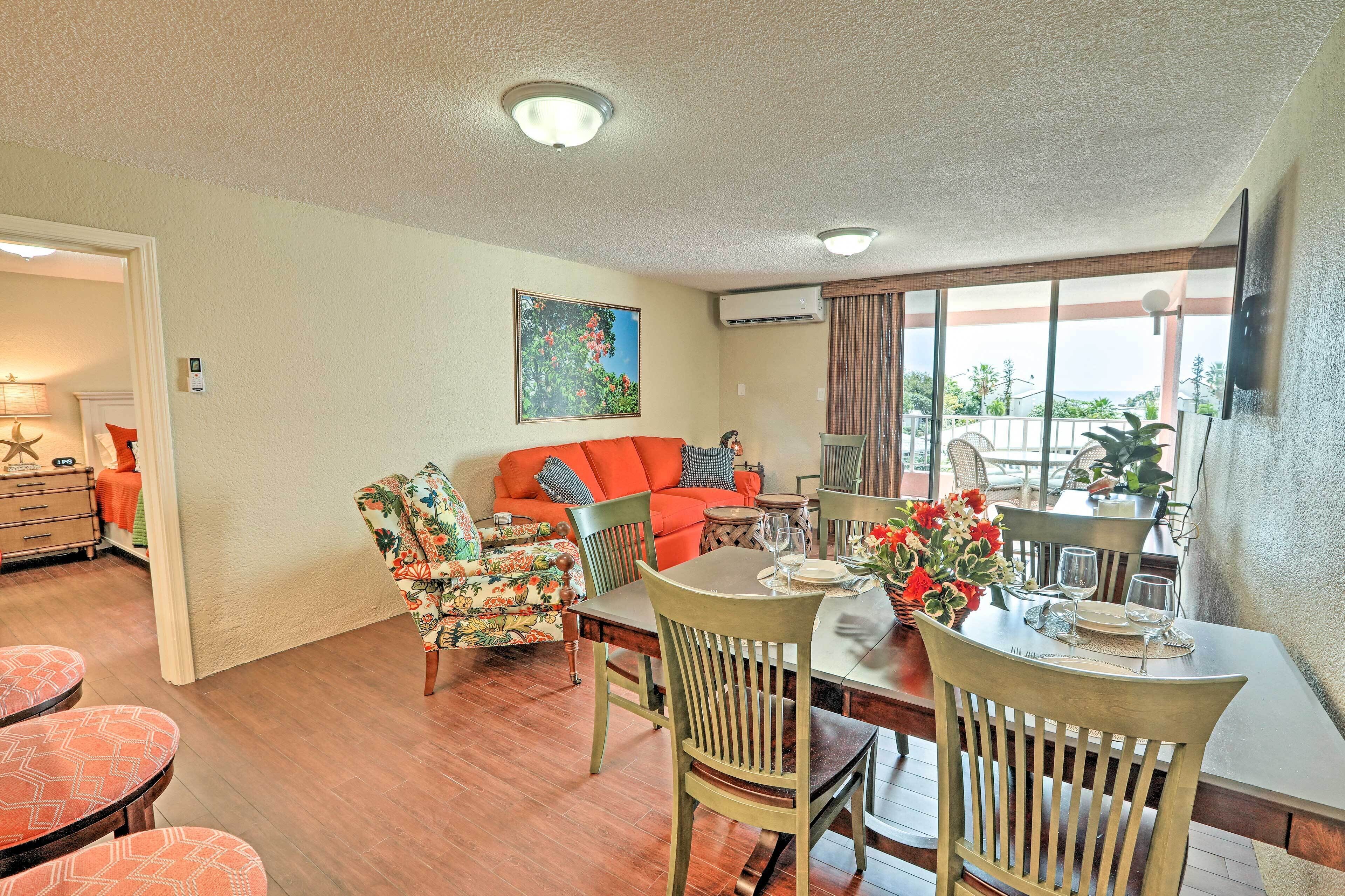 A dining area with a wooden table, chairs, and a view of the outdoors.