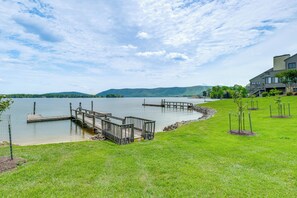 A lakeside property with a dock, grassy areas, and a building with a modern design. - Resort Condo on Smith Mtn Lake (Moneta)