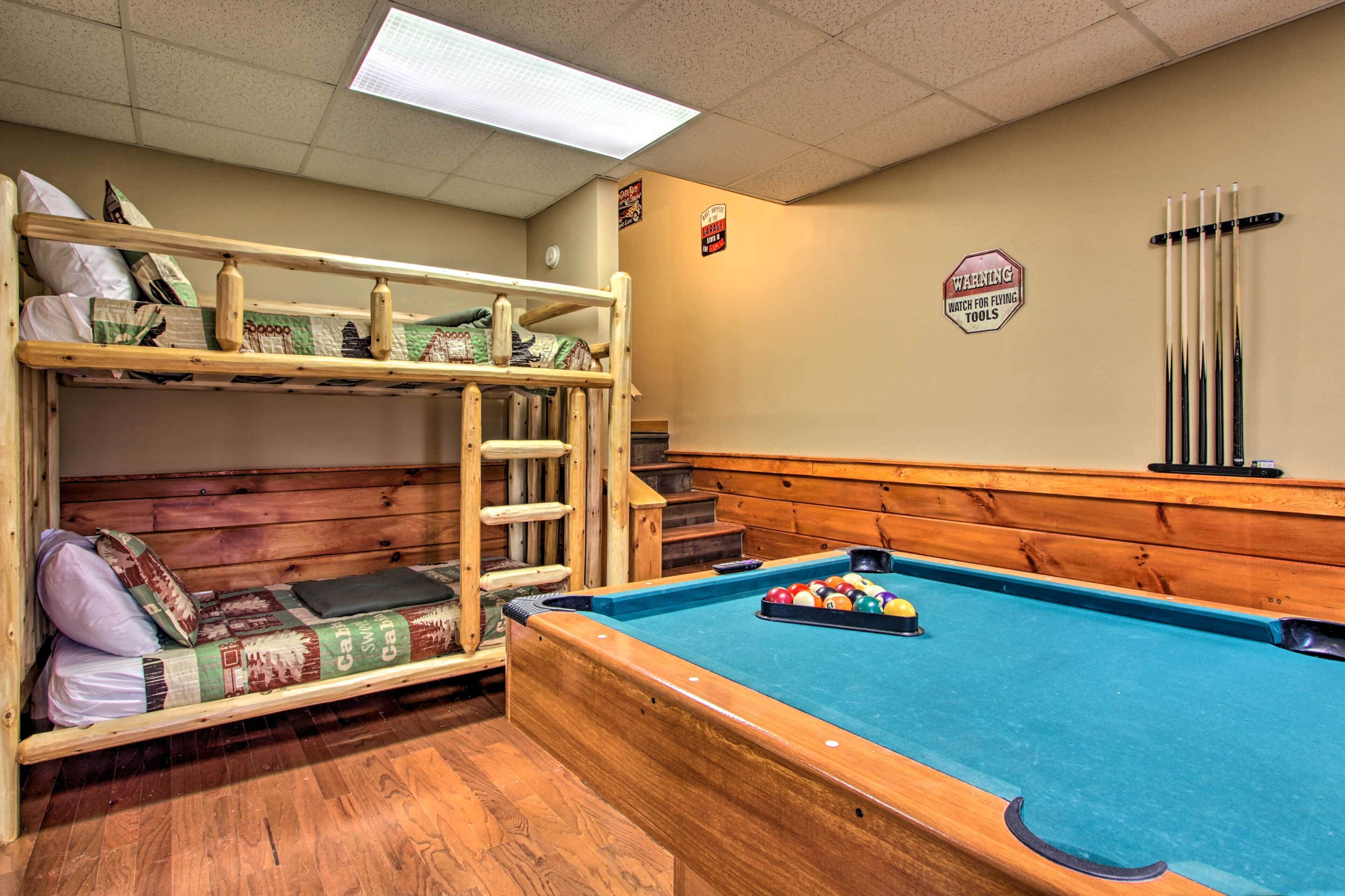 A bunk bed with a ladder, a pool table with balls, and a warning sign about flying tools.