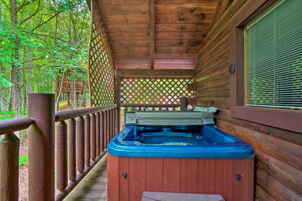 A wooden cabin with a hot tub on the porch, surrounded by a wooden deck and a lattice fence. - 'mountain Dream Cabin' w/ Deck, 7 Mi to Gatlinburg (Sevierville)