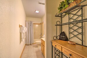A bathroom with a shower, toilet, and a wooden vanity with a basket and a bag. - 'mountain Dream Cabin' w/ Deck, 7 Mi to Gatlinburg (Sevierville)