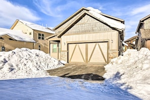 En bostadsbyggnad med ett garage, omgiven av snö.
