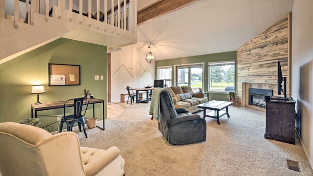 A spacious living room with a high ceiling, a fireplace, and a view of the outdoors. - Pagosa Springs Townhome w/ Mountain Views! (Pagosa Springs)