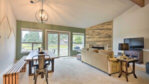 A spacious living room with a dining area, a sofa, a TV, and a fireplace. - Pagosa Springs Townhome w/ Mountain Views! (Pagosa Springs)