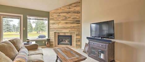 A living room with a fireplace, a sofa, a coffee table, and a television.