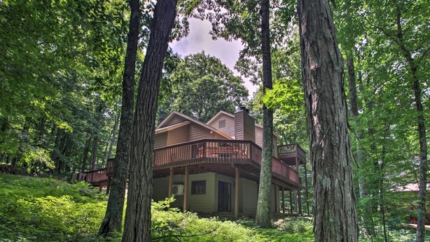 A cabin with a balcony, surrounded by dense forest. - Bright Wintergreen Resort Home; Deck & Grill! (Roseland)