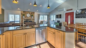 A modern kitchen with wooden cabinets, a dishwasher, and pendant lighting. - Bright Wintergreen Resort Home; Deck & Grill! (Roseland)