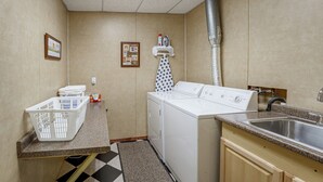 Un lavadero pequeño con lavadora, secadora y lavabo.