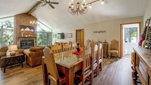 Un salón espacioso con chimenea, muebles de madera y una araña.