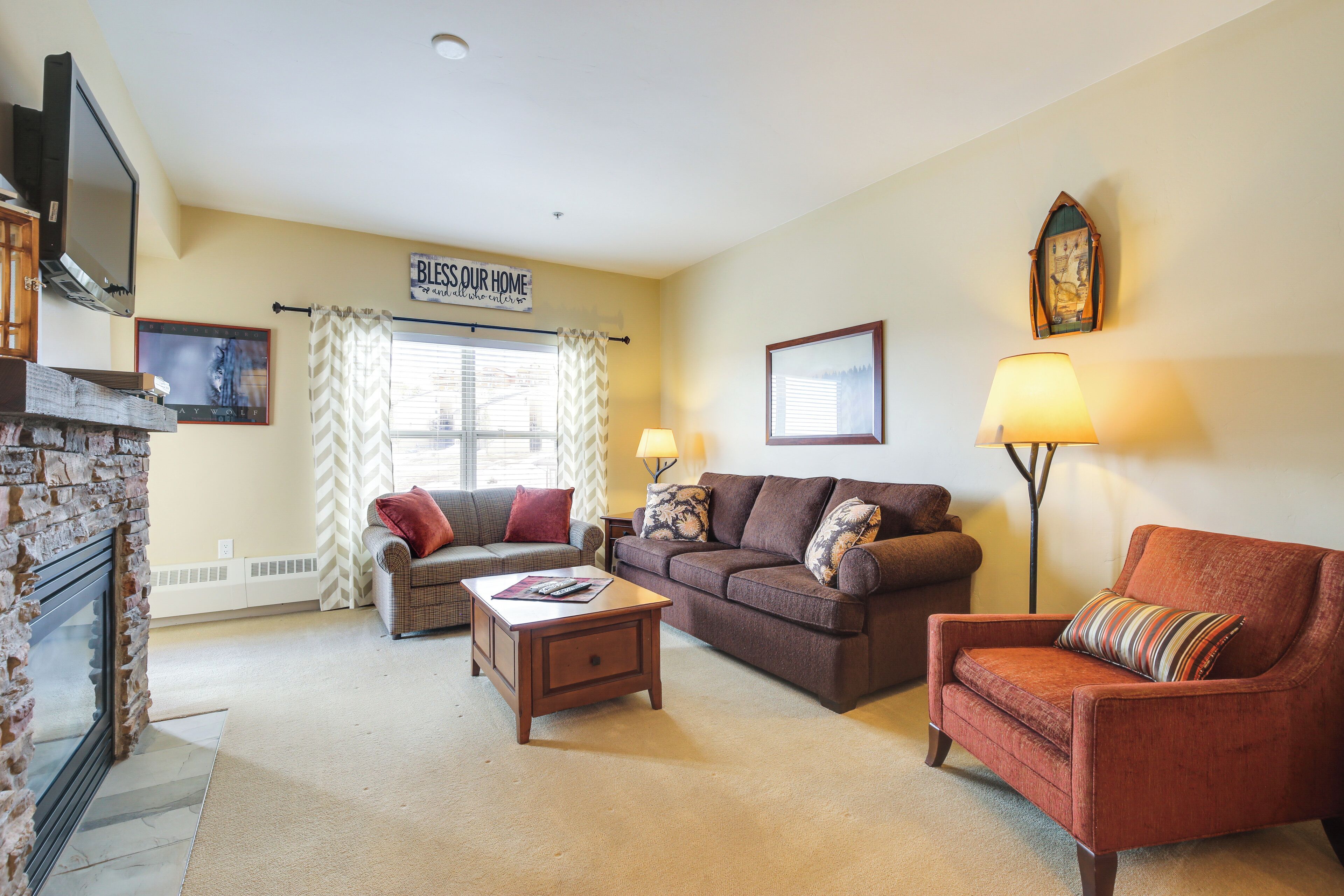 A living room with a fireplace, a sofa, a coffee table, and a lamp.