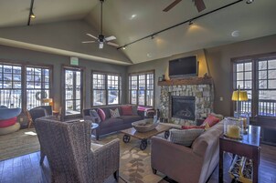 A spacious living room with a fireplace, comfortable seating, and large windows.
