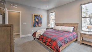 A bedroom with a bed, a painting, a window, and a nightstand. - Winter Park Area Retreat, Walk to Ski Shuttle (Fraser)