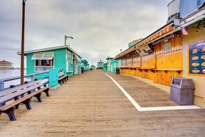 A wooden boardwalk with benches and a visitor center. - Tropical Island Escape w/ Deck, Walk to Avalon Bay (Avalon)