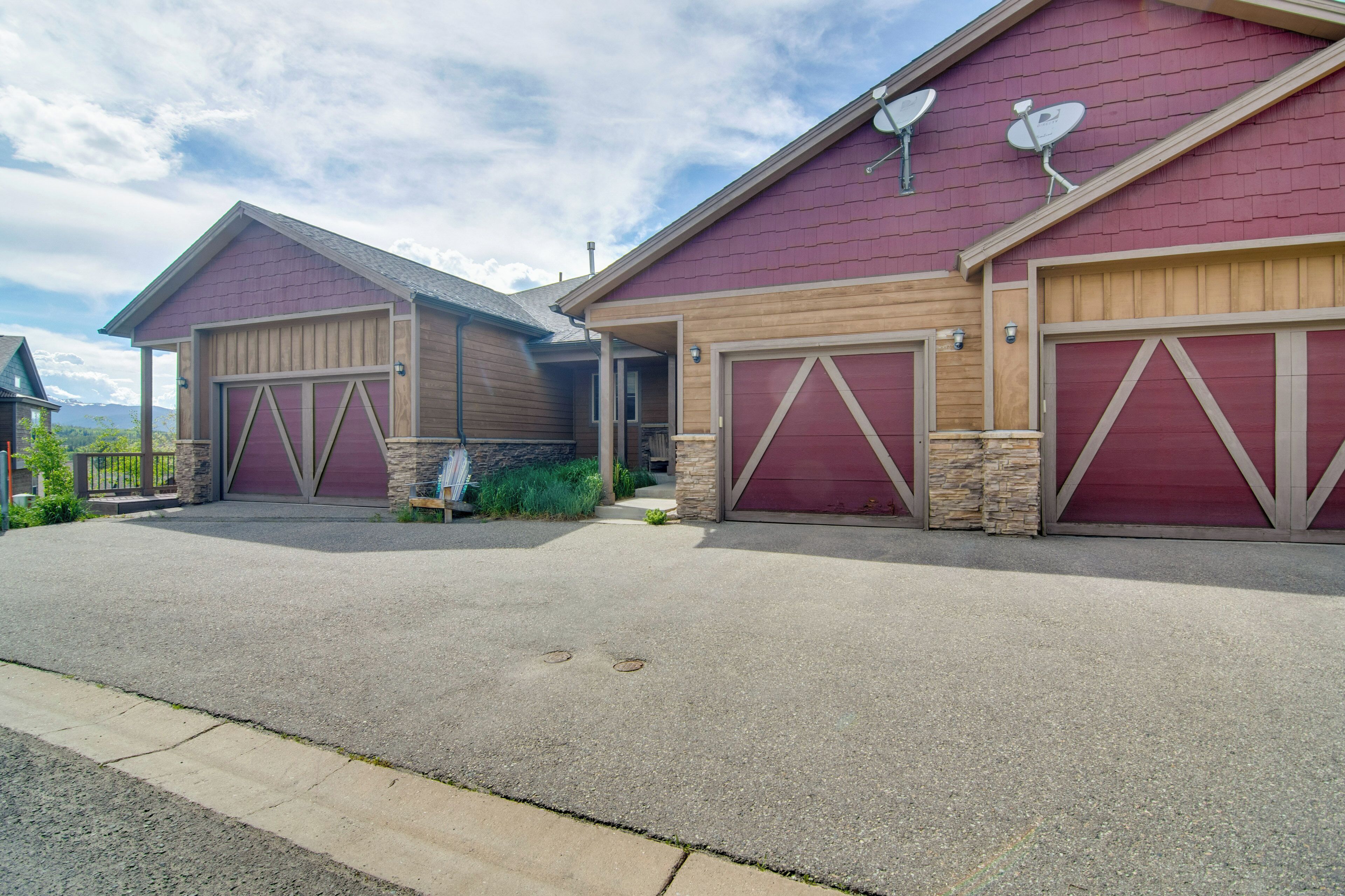 A two-story house with a red exterior and two garage doors.
