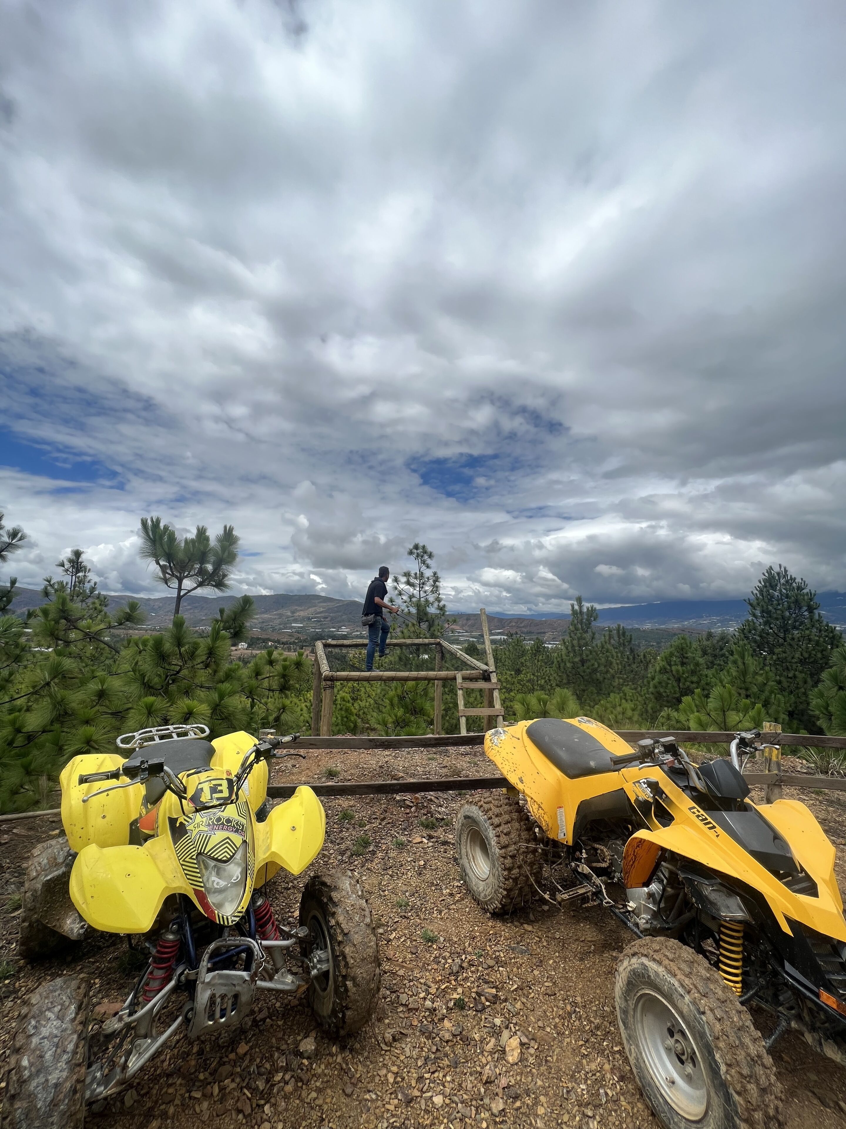 A rugged outdoor area with ATVs and a wooden platform.