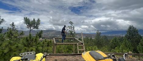 A rugged outdoor area with ATVs and a wooden platform.