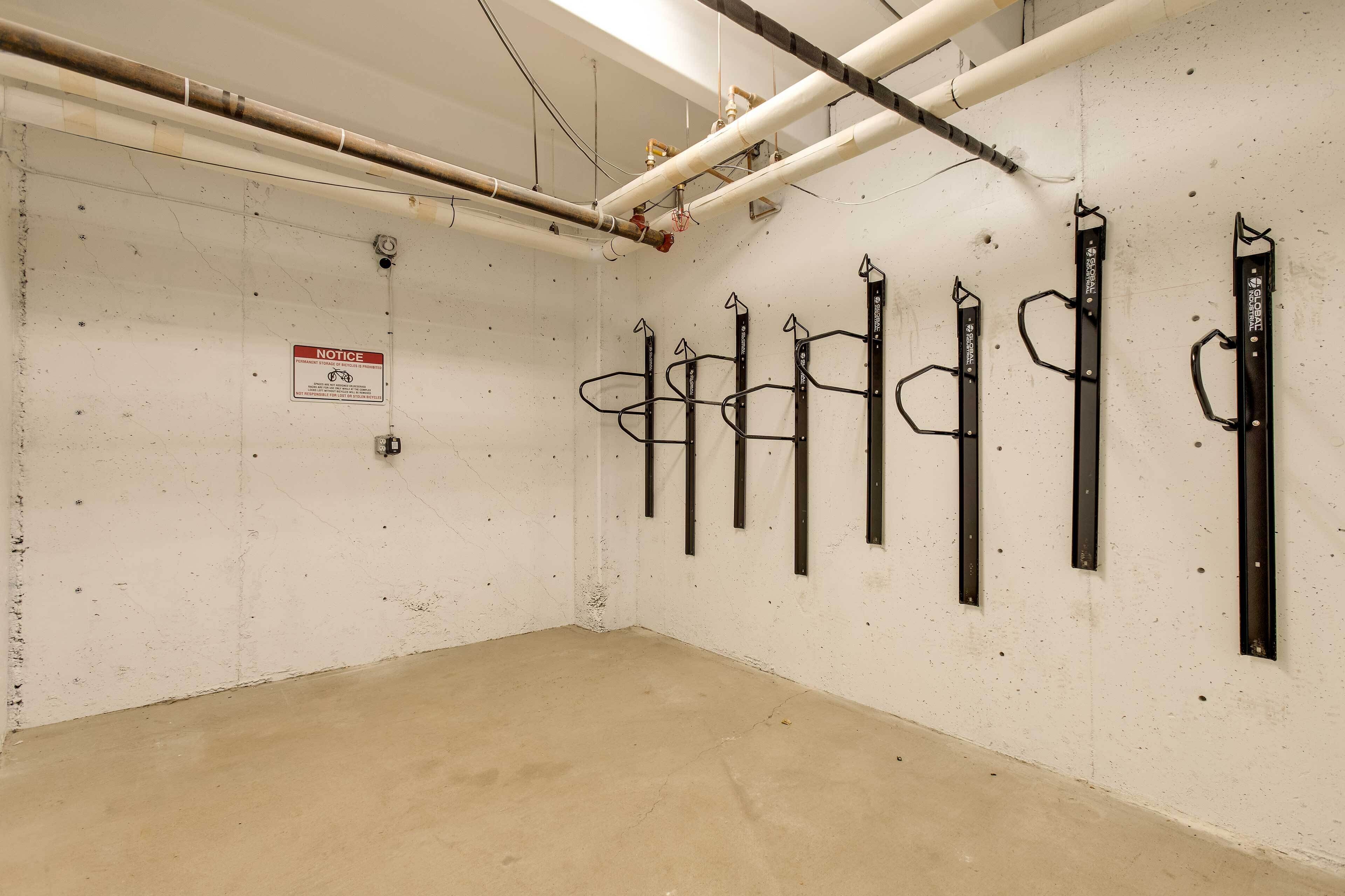 Una stanza dalle pareti bianche, un pavimento in cemento e diverse scaffalature metalliche addossate al muro.