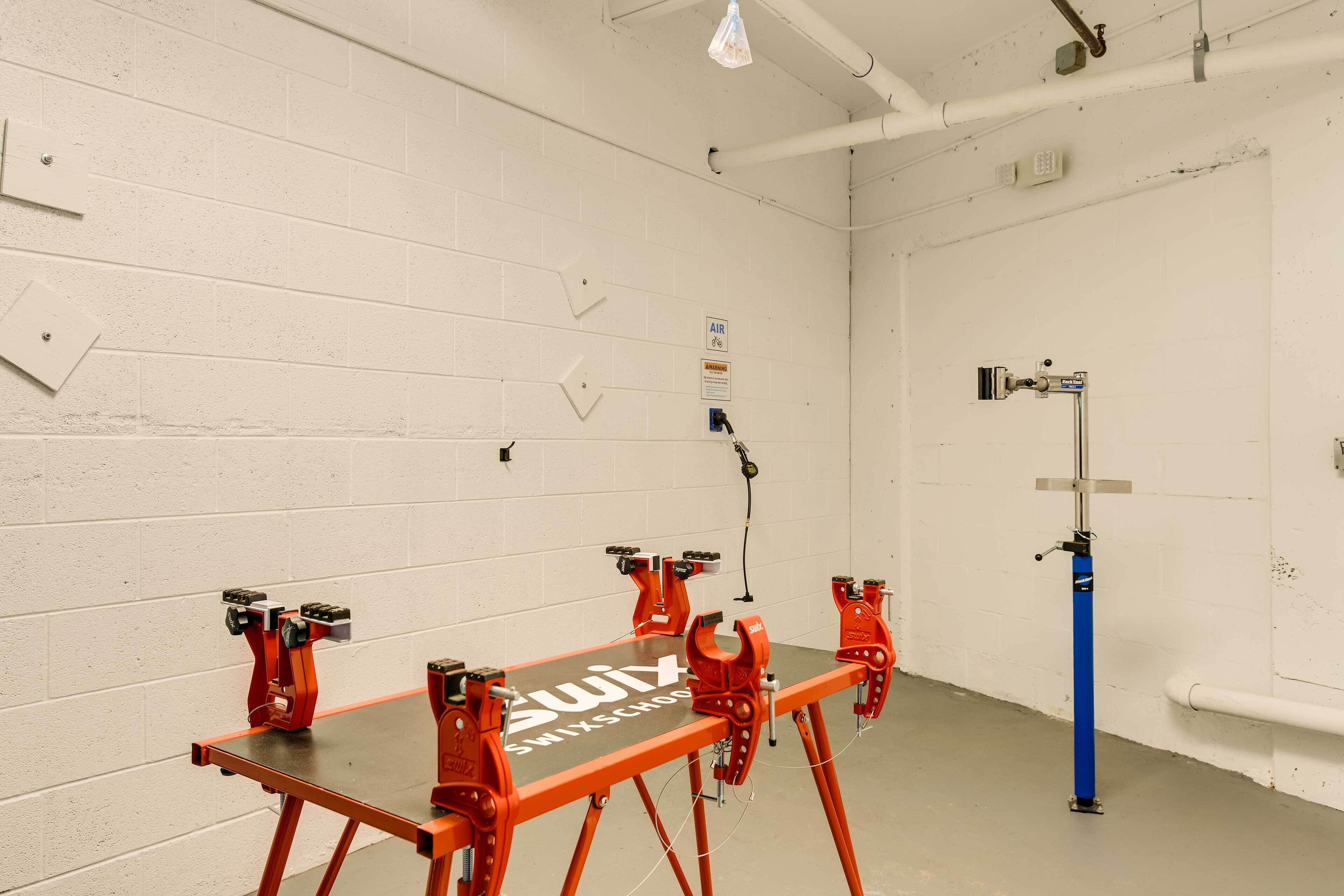 Ein Zimmer mit weißen Backsteinwänden, einem Tisch mit roten Klemmen und einem blauen Gestell.
