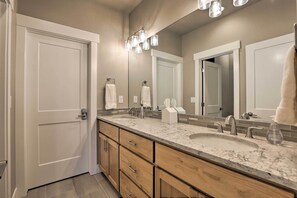 A modern bathroom with a double sink, wooden cabinetry, and a large mirror. - Fraser Retreat, Walk to Ski Shuttle & Main St (Fraser)