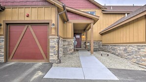 A building with a red garage door, stone exterior, and a covered entrance. - Fraser Retreat, Walk to Ski Shuttle & Main St (Fraser)