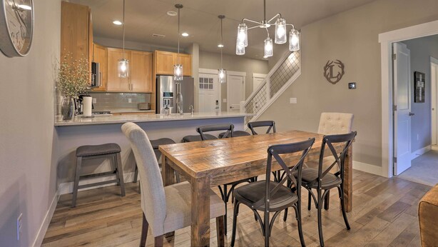 A modern kitchen with wooden cabinets, a stainless steel refrigerator, and a central island with seating. - Fraser Retreat, Walk to Ski Shuttle & Main St (Fraser)