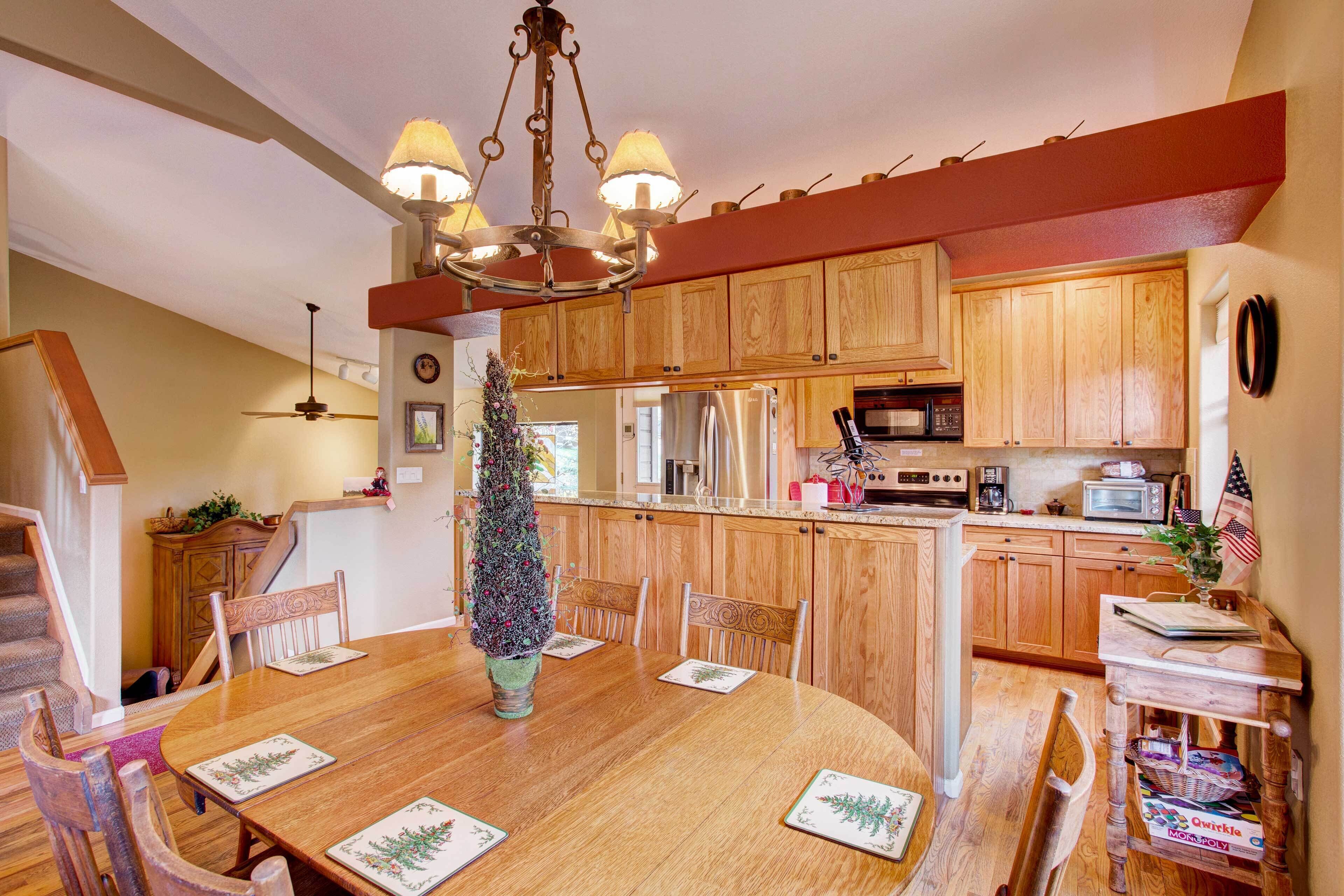 A dining area with a wooden table, chairs, and a Christmas tree.