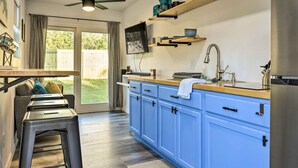 Une cuisine moderne avec des armoires bleues, un plan de travail en bois et un four encastré.