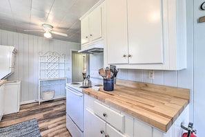 A kitchen with white cabinets, a wooden countertop, and a ceiling fan. - Inviting House 2 Mi to University of Alabama! (Tuscaloosa)