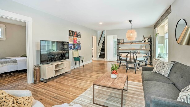 A modern living room with a TV, sofa, coffee table, and dining area. - Cozy Spokane Getaway Near Golfing & Skiing! (Spokane)