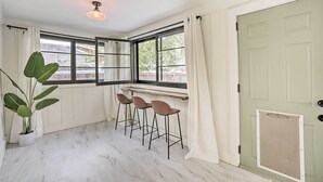 A room with a white marble floor, a large window with black frames, a white door with a small window, and a ceiling light fixture. - Cozy Spokane Getaway Near Golfing & Skiing! (Spokane)