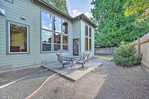 A house with a patio area featuring a table and chairs, a wooden fence, and a small tree. - Spacious Kirkland Home 15 Mi to Dtwn Seattle! (Kirkland)