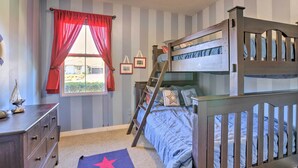 A bedroom with a bunk bed, a dresser, a window with curtains, and a star-patterned rug. - Incredible Templeton Retreat w/ Private Pool! (Templeton)