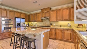 A kitchen with wooden cabinets, a granite countertop, stainless steel appliances, and a central island with bar stools. - Incredible Templeton Retreat w/ Private Pool! (Templeton)