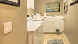 A compact kitchen with a washing machine, a sink, and a trash bin. - Incredible Templeton Retreat w/ Private Pool! (Templeton)