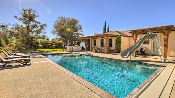 A swimming pool with a slide, lounge chairs, and a pergola. - Incredible Templeton Retreat w/ Private Pool! (Templeton)