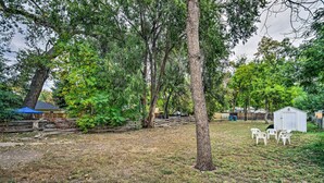 A backyard with trees, a shed, and a small patio area with chairs. - Charming Fort Collins Home By Old Town & Csu! (Fort Collins)