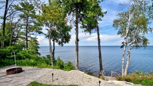 A landscaped outdoor area with a wooden deck, a small pool, and a view of the sea.