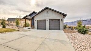 A modern two-story house with a garage, a driveway, and a mountainous backdrop. - Eden Home w/ Stunning View ~ 6 Mi to Skiing! (Eden)