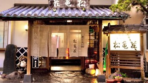 Un edificio japonés tradicional con tejado de tejas y señalización en caracteres japoneses.
