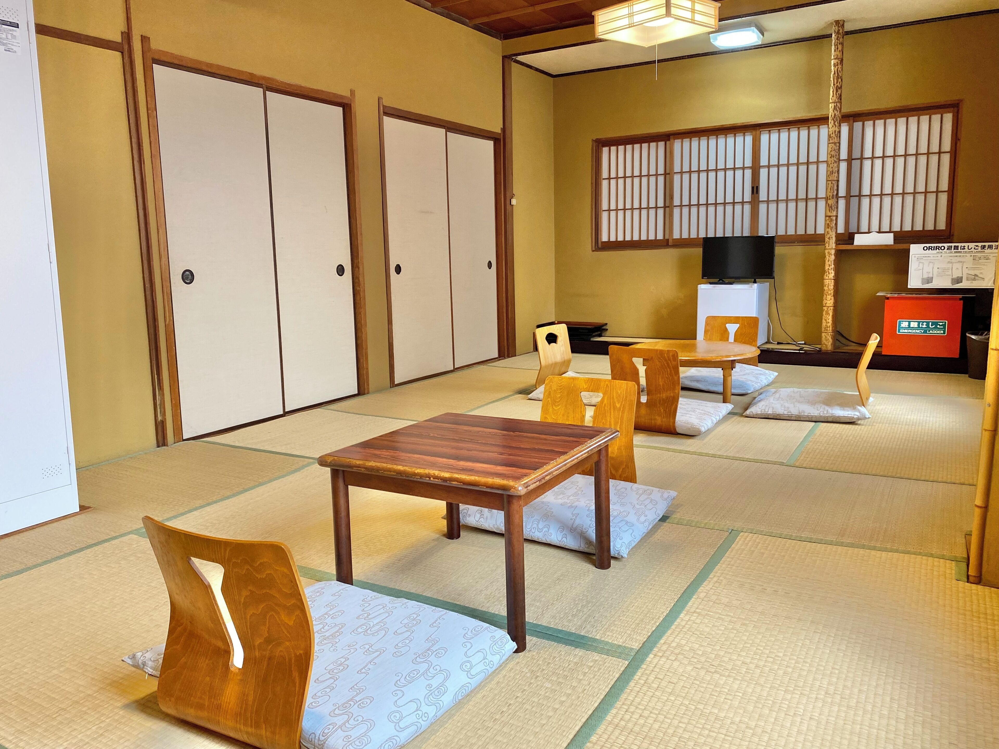 A traditional Japanese room with tatami flooring, wooden furniture, and shoji screens.