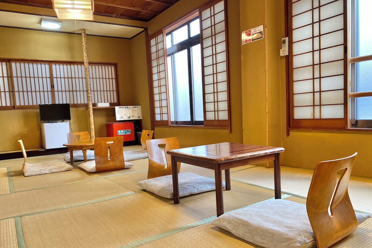 A traditional Japanese room with tatami flooring, wooden furniture, and shoji screens.