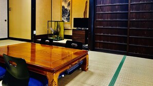 Una habitación tradicional japonesa con suelo de tatami, una mesa de madera y un panel shoji.