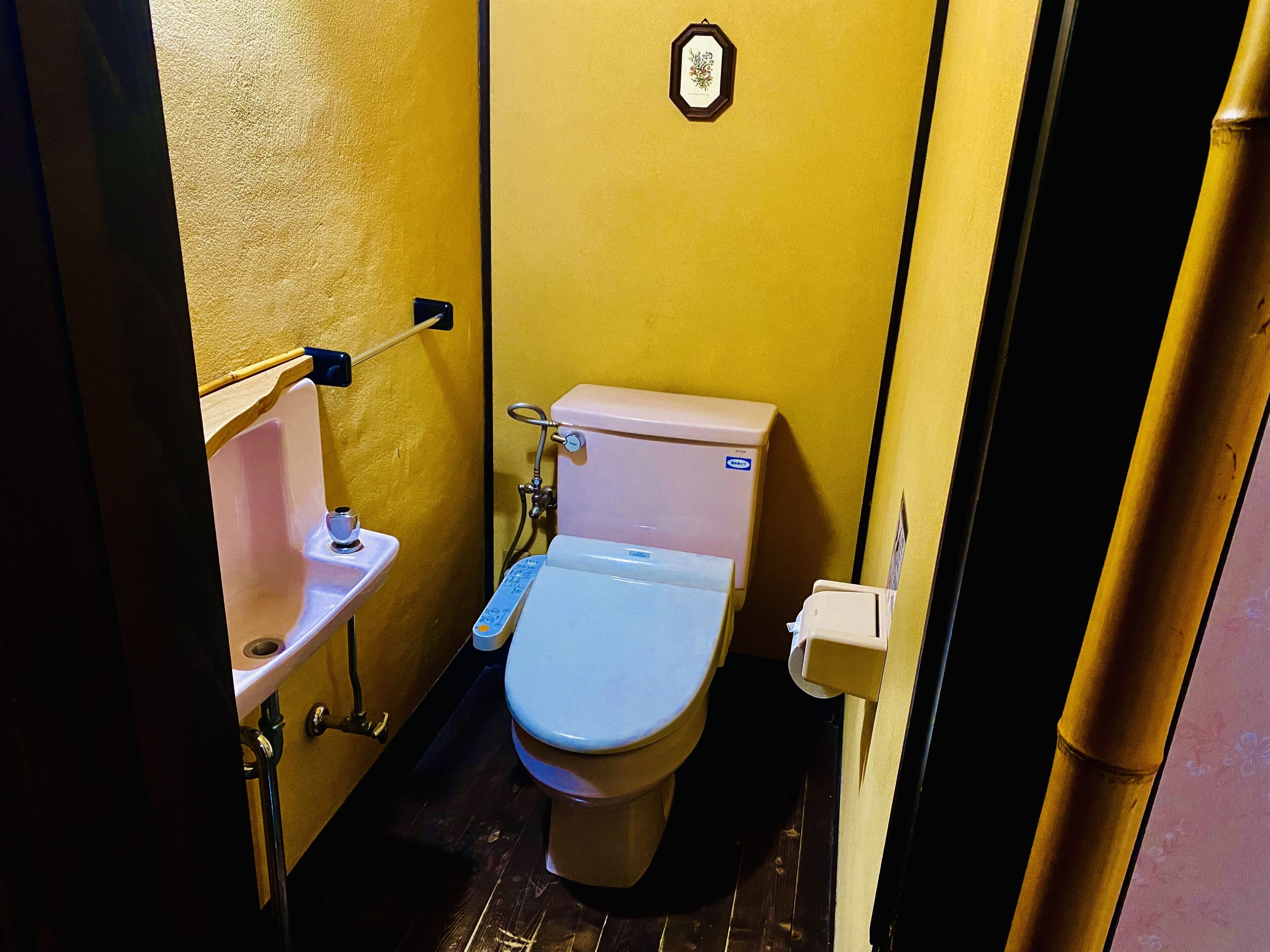 A small bathroom with a toilet, sink, and shower.