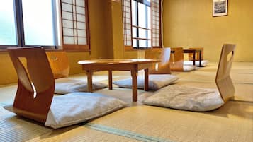 Pavimento de esteras de tatami, muebles de madera y puertas correderas shoji en una habitación tradicional.