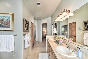 A modern bathroom with dual sinks, a large mirror, and decorative flowers. - 2 Mi to Downtown Sante Fe: 4BR Retreat w/ Patio (Santa Fe)