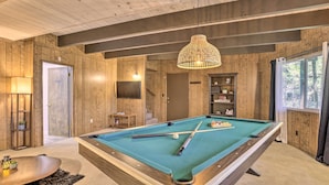A pool table in a room with wooden walls and a ceiling with exposed beams. - Lake Arrowhead Cabin w/ Mid-century Charm! (Lake Arrowhead)